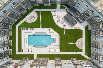A bird's eye view of a courtyard with a pool and a soccer field.